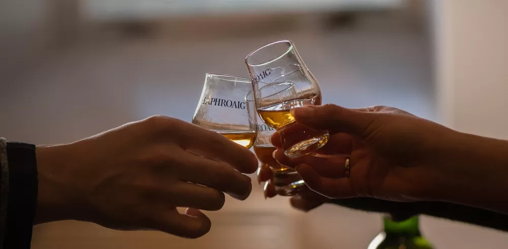 Laphroaig whisky being toasted in dram glass